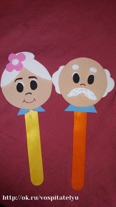 two children's paper puppets with faces on them