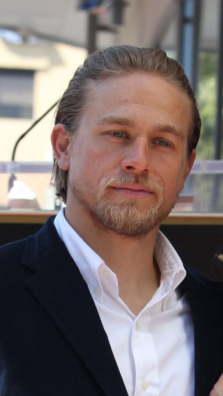 a man in a suit and tie standing next to another man wearing a white shirt