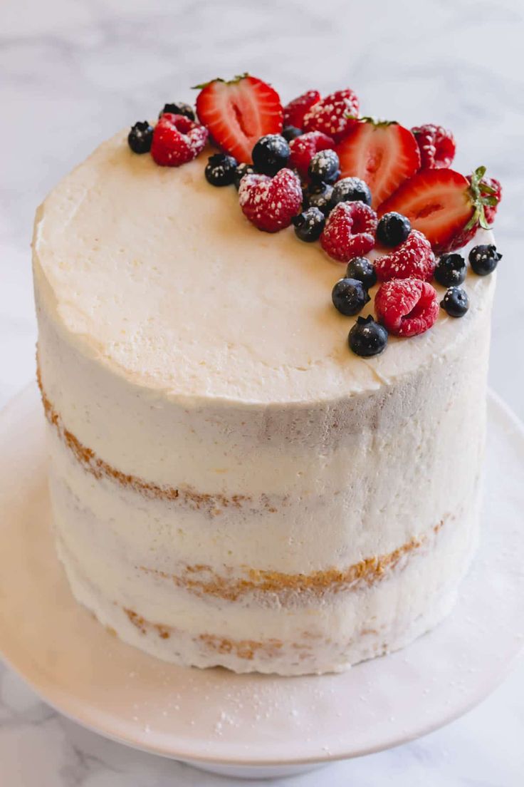 a white cake with berries and blueberries on top