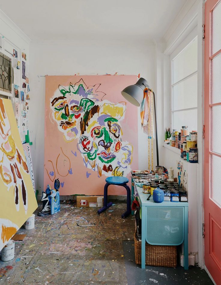 an artist's studio with paintings on the wall