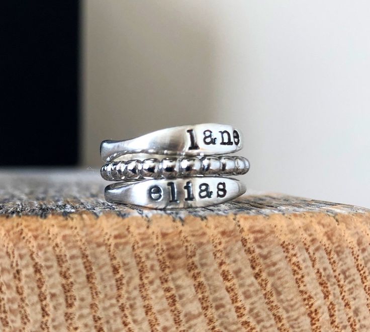 Enjoy FREE shipping on all domestic orders Also order with confidence as all of my orders are being processed and shipped on time according to my 1-2 week processing time. This beautiful ring set is the perfect way to carry your loved ones with you all the time Made from sterling silver U.S Whole sizes only This listing is for two sterling rings and a stainless steel beaded spacer, if you would like one ring please message me :) Please leave your name or date in the notes at checkout, currently Meaningful Silver Stackable Rings Gift, Silver Stackable Rings For Gift, Meaningful Style, Personalized Silver Stackable Rings For Mother's Day, Adjustable Silver Rings With Meaningful Style, Adjustable Silver Meaningful Rings, Personalized Silver Ring With Meaningful Style, Silver Hand Stamped Rings For Mother's Day, Silver Stackable Rings For Mother's Day Promise, Meaningful Adjustable Silver Stackable Rings