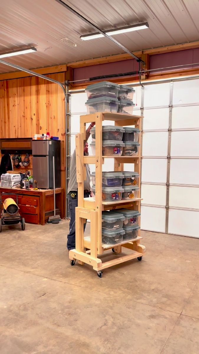 a man standing next to a stack of plates in a garage