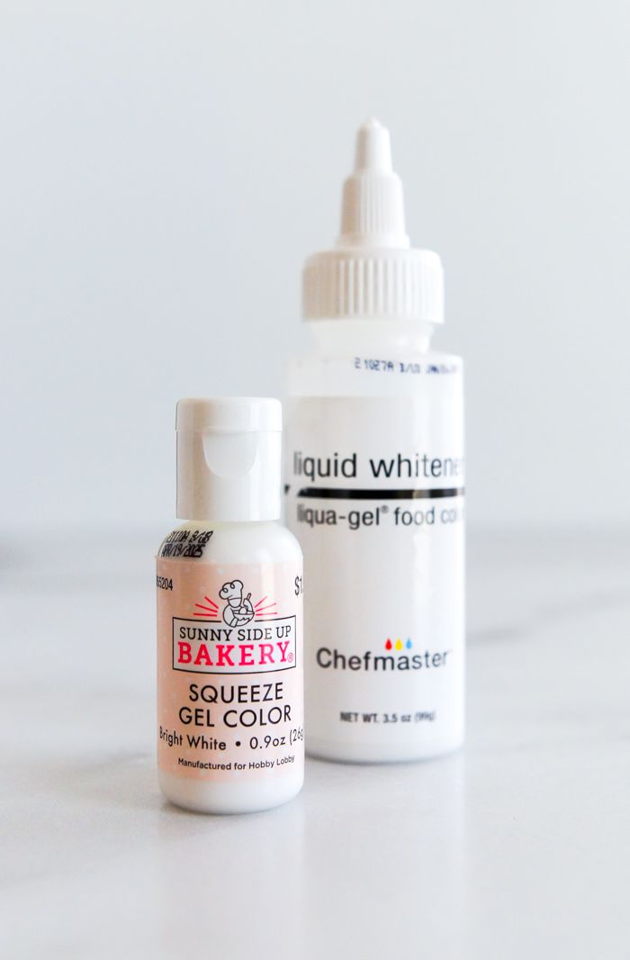 two bottles of liquid sitting next to each other on a white counter top, one containing baking powder and the other containing bakery