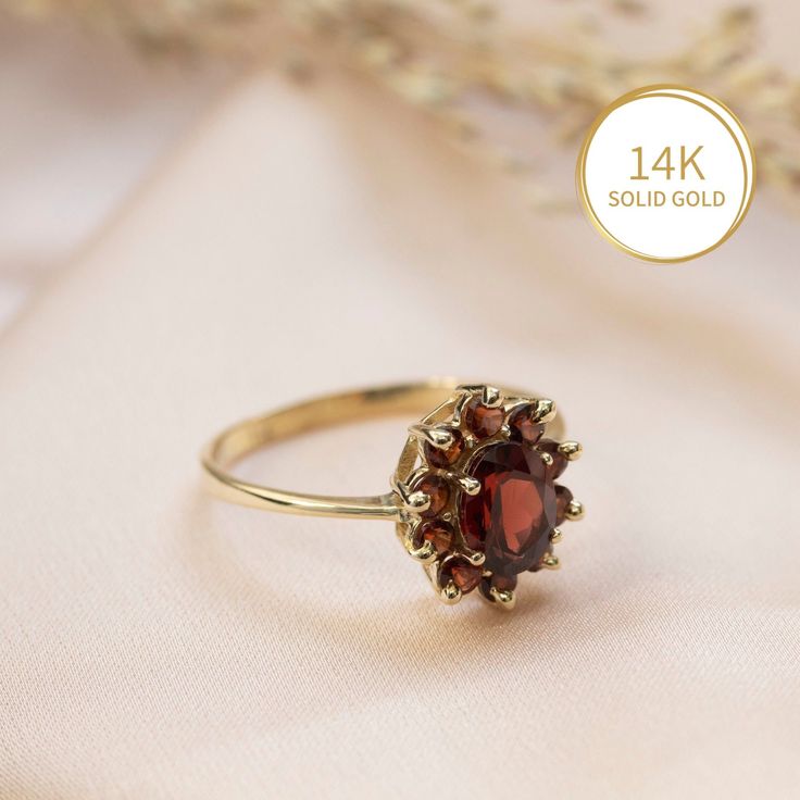 Elegant Garnet Flower ring in 14k yellow gold, multi stone halo engagement, wedding or promise ring for women.   This beautiful handmade ring is made of solid 14k yellow gold and is set with a faceted oval garnet, surrounded by a halo of 10 faceted smaller round garnets. The deep red of the gemstones combined with the classic halo design give this ring a regal look that cannot be ignored.   Garnet is January's birthstone.  This ring can be a wonderful engagement/promise/wedding ring, or a gift f Yellow Gold Garnet Rings For Anniversary, Oval Red Cluster Ring With Center Stone, Heirloom Cluster Ring Gift, Red Cluster Halo Setting Jewelry, Garnet Cluster Ring For Promise, Fine Jewelry, Garnet Cluster Promise Ring In Fine Jewelry Style, Red Diamond Cluster Ring In 14k Gold, Formal Red Gemstone Flower Ring, Red Cluster Diamond Ring In 14k Gold