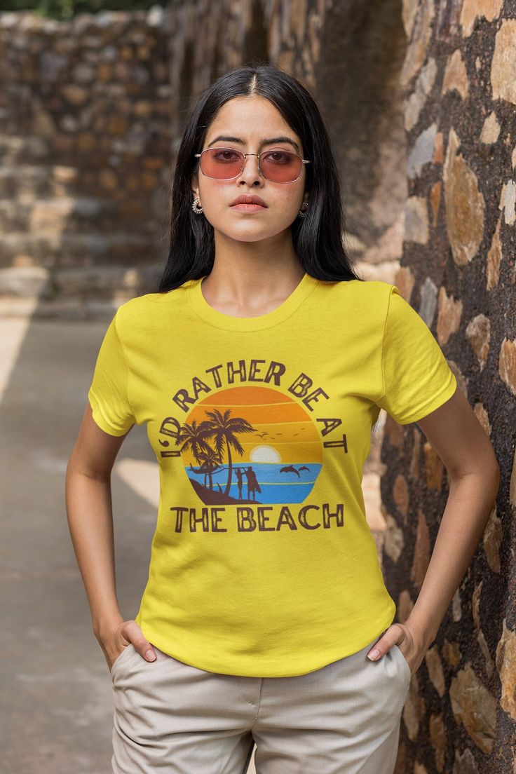 Indulge yourself in the ultimate comfort and fashion with this charming 'I'd rather be at the beach' unisex t-shirt. It is crafted from wonderfully soft materials that are guaranteed to give you the coziness you're looking for. Its fabric is 100% cotton for solid colors and mix of polyester and cotton for heather colors and sports grey. Its ribbed collar construction prevents curling damage, and the twill tape shoulders improve its durability. The Eurofit fit makes it a figure-flattering top tha Cotton Graphic Tee For Beach Party, Yellow Relaxed Fit T-shirt For Summer, Yellow Crew Neck T-shirt For Beach, Yellow Letter Print T-shirt For The Beach, Yellow Summer T-shirt For Beach, Beach Yellow T-shirt With Letter Print, Yellow Slogan T-shirt For Summer, Beach T-shirt With Letter Print In Yellow, Funny Print Relaxed Fit T-shirt For Beach Party