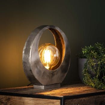 a light that is sitting on top of a wooden table next to a potted plant