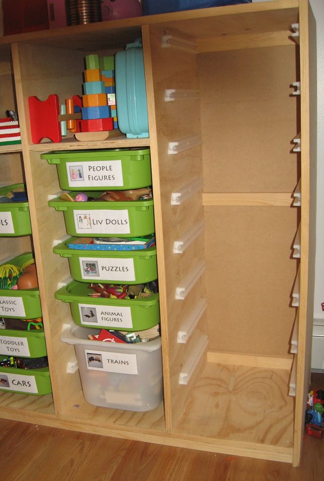 the shelves are filled with plastic containers and bins for children's playtime