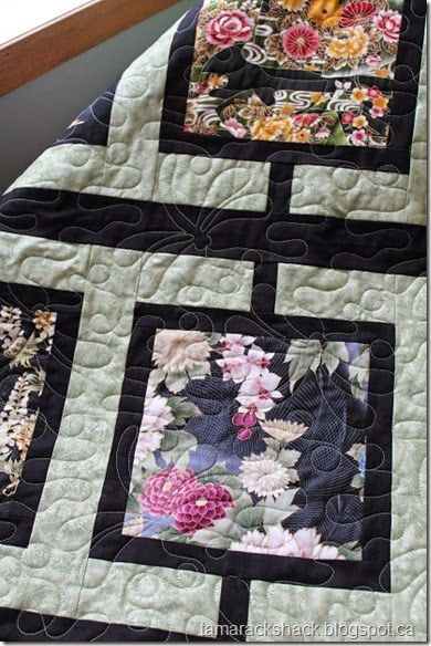 a close up of a quilt on a window sill with flowers in the center