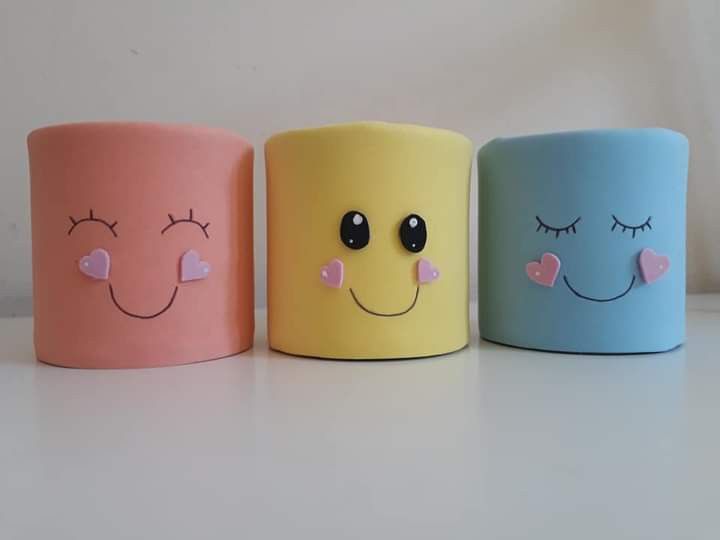 three different colored cups with faces painted on them