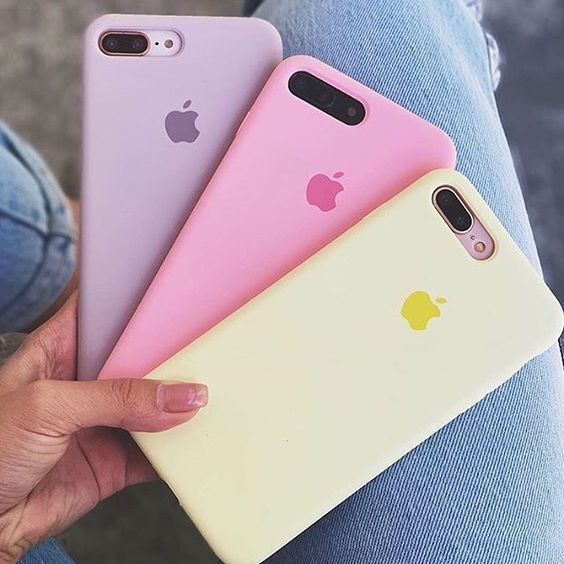 three different colored iphones sitting next to each other in someone's lap top