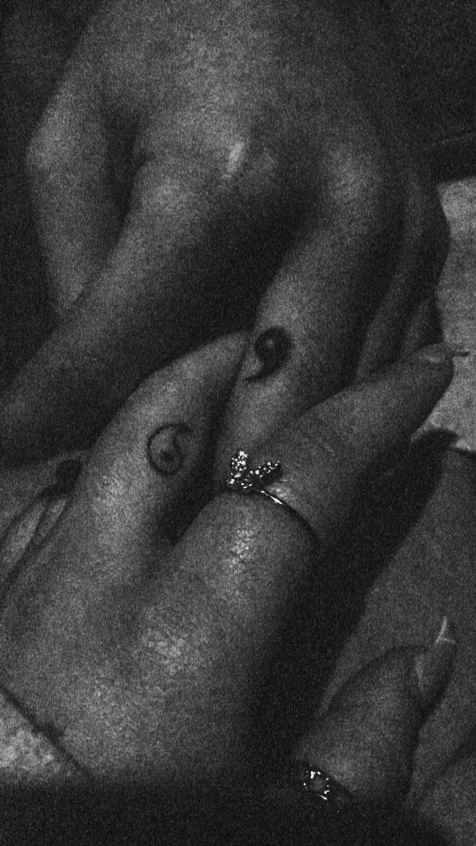 black and white photograph of two people with rings on their fingers