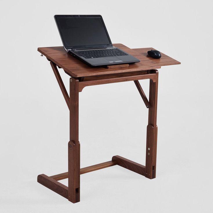 a laptop computer sitting on top of a wooden table next to a mouse and keyboard