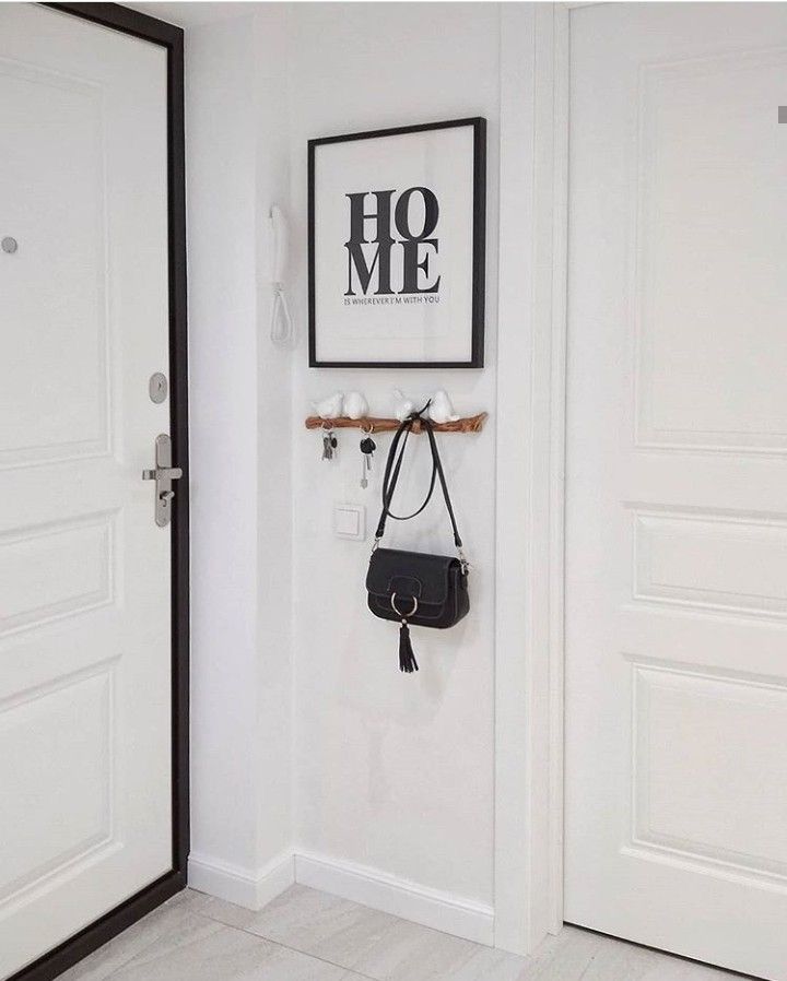 a black and white photo hangs on the wall next to a door with a purse hanging from it