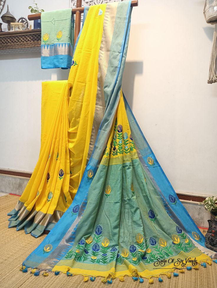 Elevate your ethnic wardrobe with our stunning handloom pure cotton saree in vibrant yellow, adorned with a magnificent firoza-colored temple woven border. This saree is a masterpiece of craftsmanship, featuring intricately embroidered multicolor floral design, neatly and artistically crafted onto the fabric. In addition to its exquisite design, this saree is designed for comfort and style. Crafted from pure, soft cotton, it offers a luxurious and comfortable drape, making it a joy to wear on any occasion. To complete the ensemble, a matching blouse piece with delicate embroidery work is included. Discover the perfect blend of tradition, artistry, and comfort with this exceptional pure cotton saree. Elevate your fashion quotient while celebrating the rich heritage of Indian textiles. Shop Yellow Semi-stitched Cotton Silk Saree, Yellow Traditional Wear With Resham Embroidery In Mulmul, Yellow Mulmul Traditional Wear With Resham Embroidery, Yellow Embroidered Saree In Traditional Drape, Yellow Embroidered Mulmul Traditional Wear, Yellow Embroidered Saree With Traditional Drape, Yellow Embroidered Art Silk Saree, Cotton Dupatta With Embroidered Border, Yellow Cotton Dupatta With Zari Work