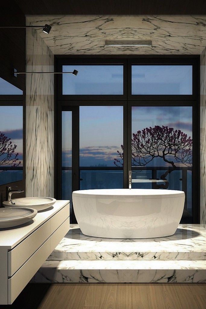 a large white bath tub sitting next to a bathroom sink in front of a window