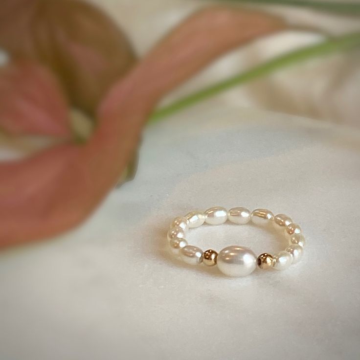 Delicate elastic fresh water pearl ring with 14kt gold filled beads. Carefully selected and high quality lustrous pearls make the ring truly beautiful and one of a kind. The delicate and minimalist design of the ring goes well with both casual and sophisticated looks. Pair it with other rings at our shop to make your own individual set. Size of the small pearl beads is approx. 2-2.5mm Size of the center large bead: 3.5-4mm Size of the gold filled bead: 2.5mm Follow us on INSTAGRAM: @soelle_jewel Sterling Silver Birthstone Ring, Elastic Rings, June Birthstone Ring, Stretch Ring, Beaded Ring, Handmade Jewelry Tutorials, Gold Filled Ring, Wedding Ring Set, June Birthstone