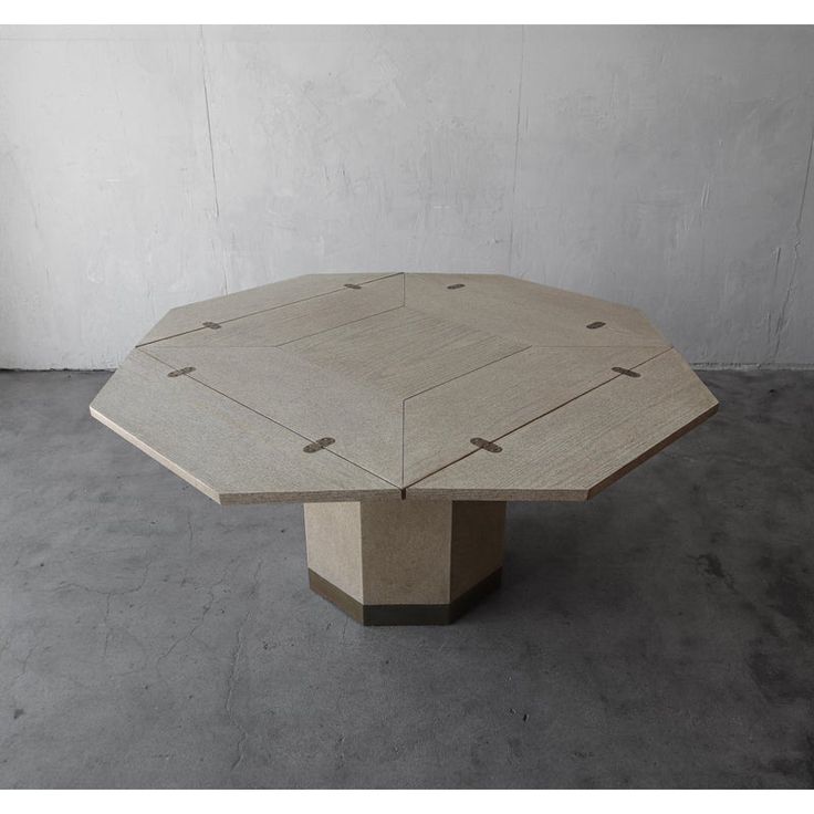 a concrete table sitting on top of a cement floor next to a white wall in an empty room