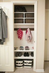 an organized closet with shoes and coats hanging on the door, next to two baskets filled with clothes