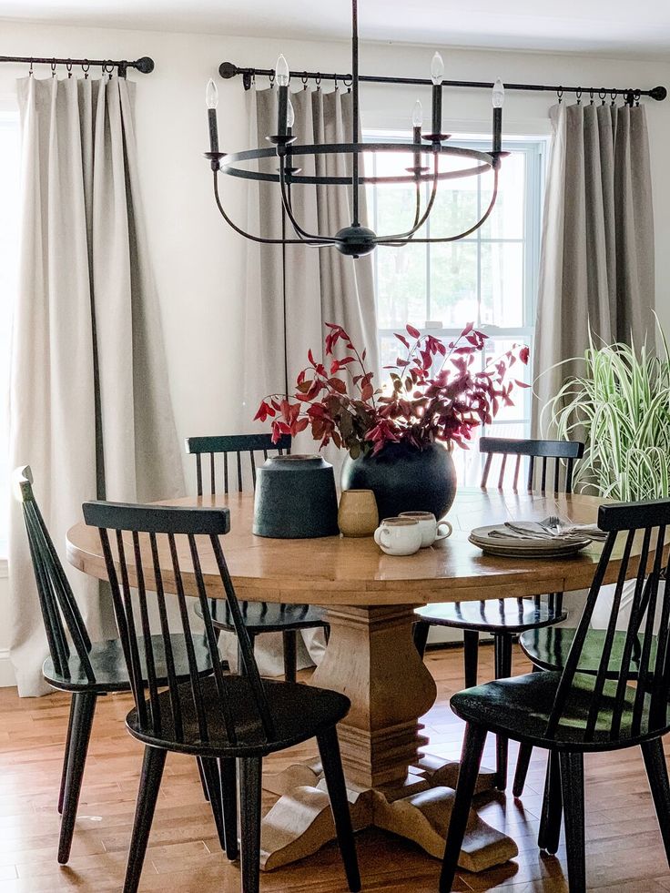 a dining room table with four chairs and a potted plant on top of it