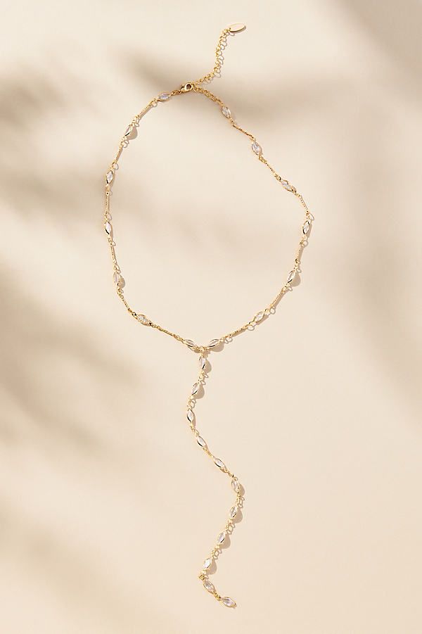 14k gold-plated brass, cubic zirconia Lobster clasp Imported | Crystal Lariat Necklace by Anthropologie in Gold, Women's, Gold/Plated Brass/Cubic Zirconia Drop Chain Necklace, Crystal Lariat Clavicle Chain Jewelry, Crystal Clavicle Chain Lariat Jewelry, Gold Cubic Zirconia Chain Necklace For Wedding, Elegant Lariat Chain Necklace With Lobster Clasp, Elegant Lariat Crystal Necklace, Gold Cubic Zirconia Lariat Backdrop Necklace, Formal Crystal Lariat Jewelry, Crystal Lariat Necklace With Adjustable Chain