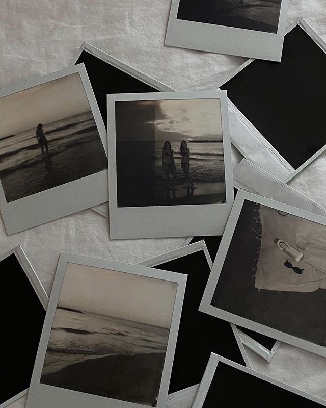 several polaroid photos are laying on a sheet with one person holding a surfboard