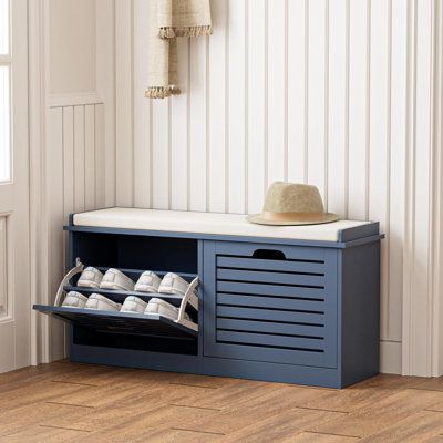 a blue shoe rack with shoes on it next to a white wall and wooden floor