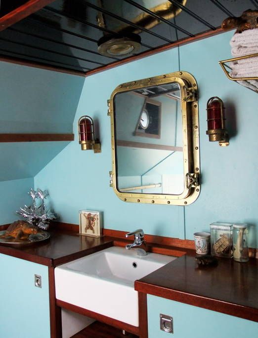 there is a sink and mirror in the bathroom with blue walls, wood counter tops and drawers