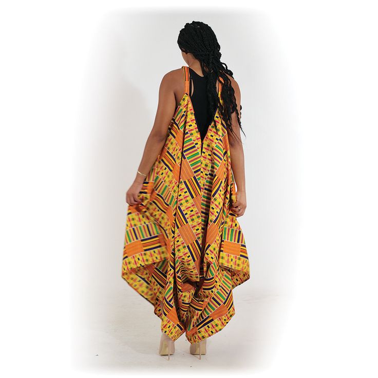 Bold and colorful, this Kente Jumpsuite #1 is a uniquely African addition to any wardrobe. The jumpsuit has a halter top with straps and an unconstructed bodice that flows into wide-legged pants. It features a distinctive Kente pattern in orange, yellow and green. It comes with two convenient pockets. Jumpsuit is 48” in length. It fits up to a 64” elastic bust. Made in India of 100% cotton. Machine wash in cold water. C-WH368 Kente Jumpsuit, Kente Pattern, Palazzo Jumpsuit, African Dashiki, Loose Jumpsuit, Pantsuits For Women, Yellow And Green, African Print, African Fashion