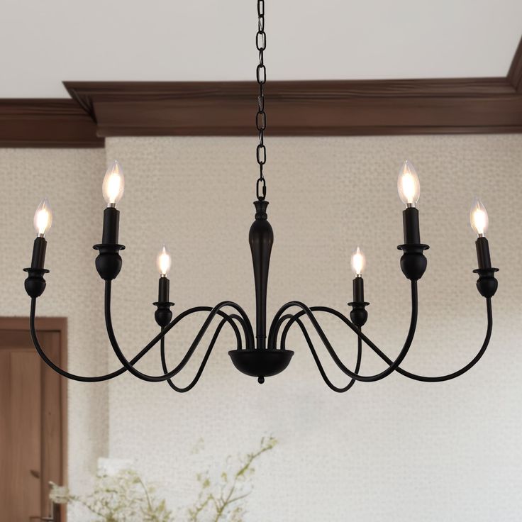 a chandelier with five lights hanging from the ceiling in a dining room area