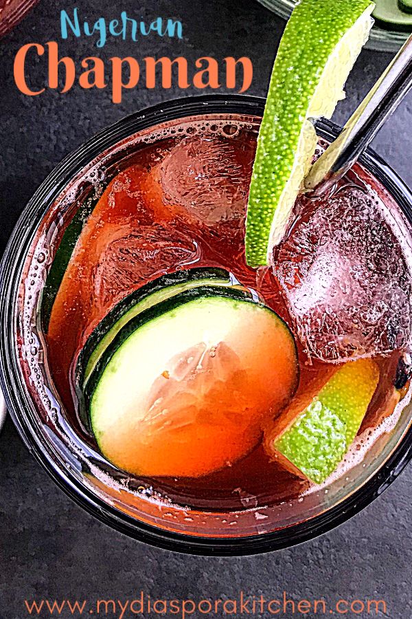 a close up of a drink in a glass on a table with ice and lime