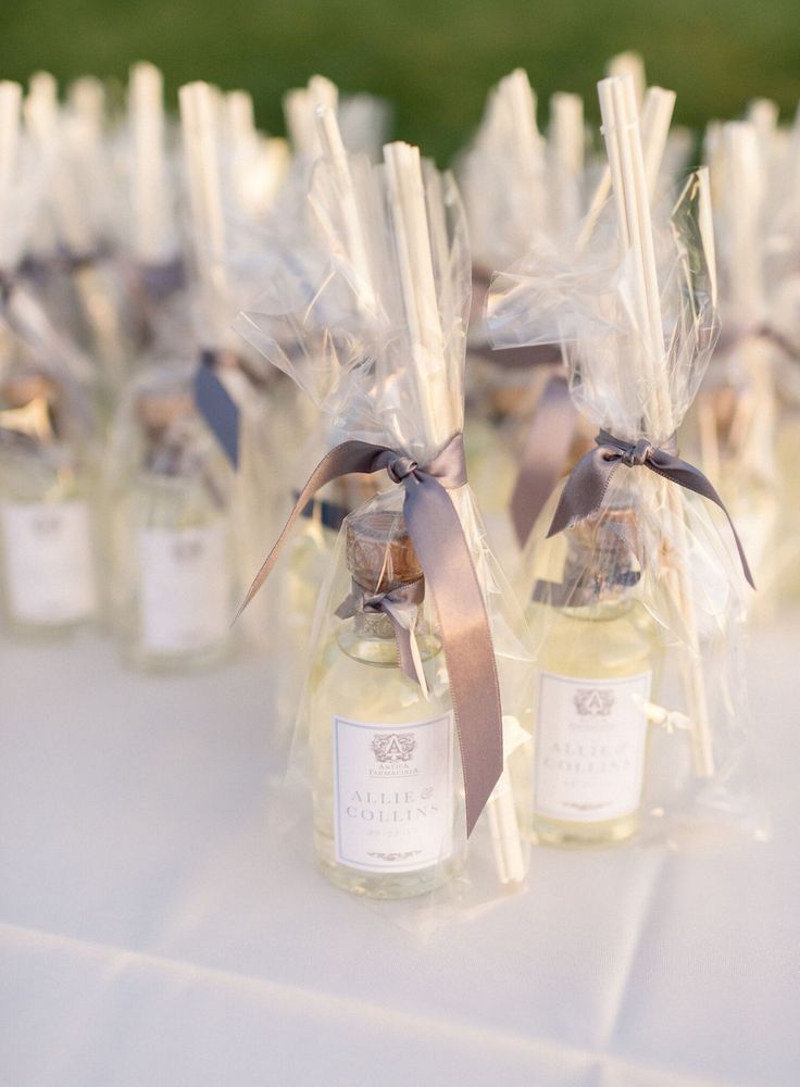 small bottles filled with perfumes on top of a white table cloth covered tablecloth