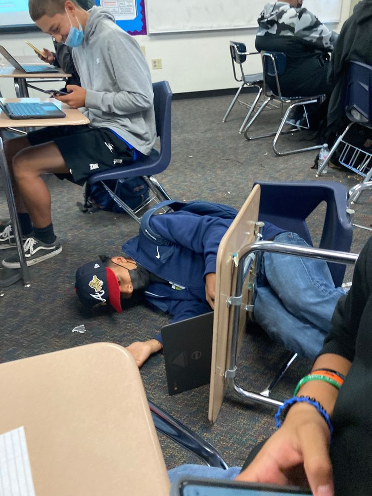 a group of people sitting at desks working on laptops