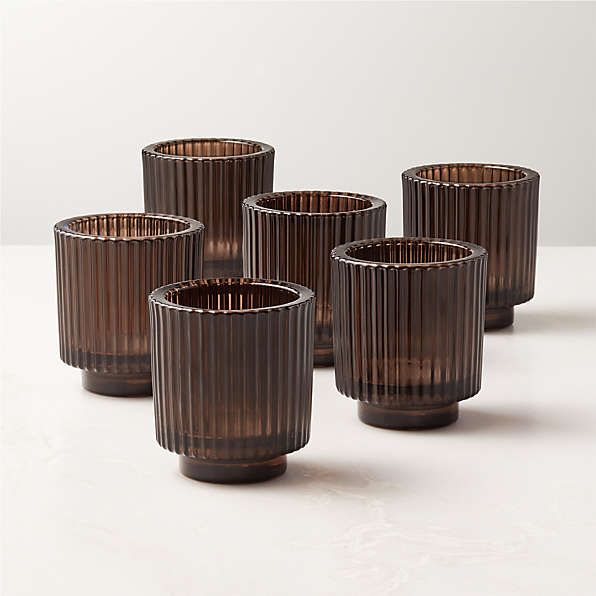 four brown glass cups sitting on top of a table