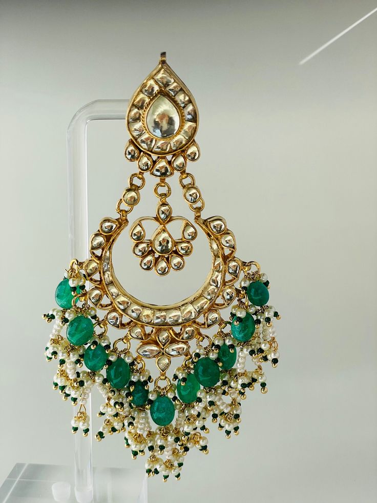 Green Morni long earring will surely make you look like a royalty.A refined handmade jewellery engraved with real kundan stones. Each piece has an intricate bead work to enrich its elegance. Temple Jewelry Stone Work Danglers For Celebration, Temple Jewelry Danglers With Stone Work For Celebration, Traditional Festive Hand Set Chandbalis, Festive Traditional Hand-set Chandbalis, Traditional Festive Chandbalis With Hand Set Details, Temple Jewelry Style Bridal Earrings With Stone Work, Elegant Kundan Chandbali Chandelier Earrings, Temple Style Bridal Earrings With Stone Work, Elegant Kundan Danglers For Celebration