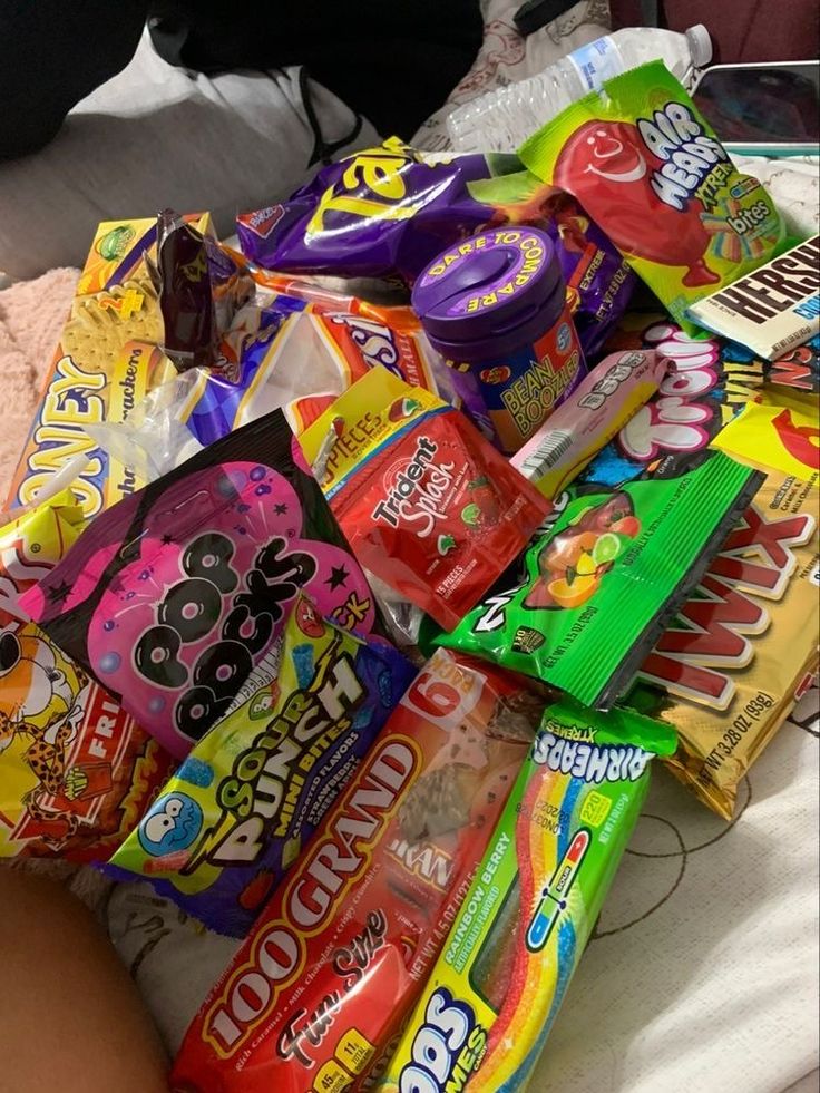 a pile of candy sitting on top of a bed