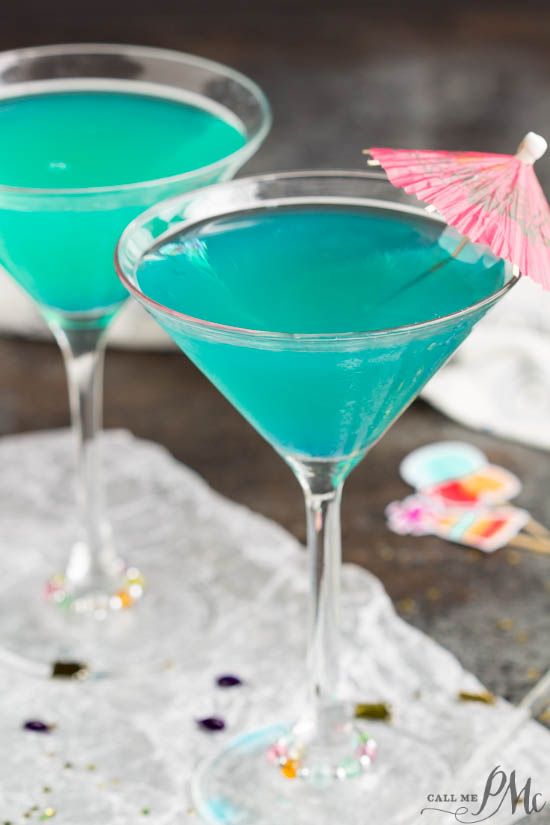 two martini glasses with blue liquid and an umbrella