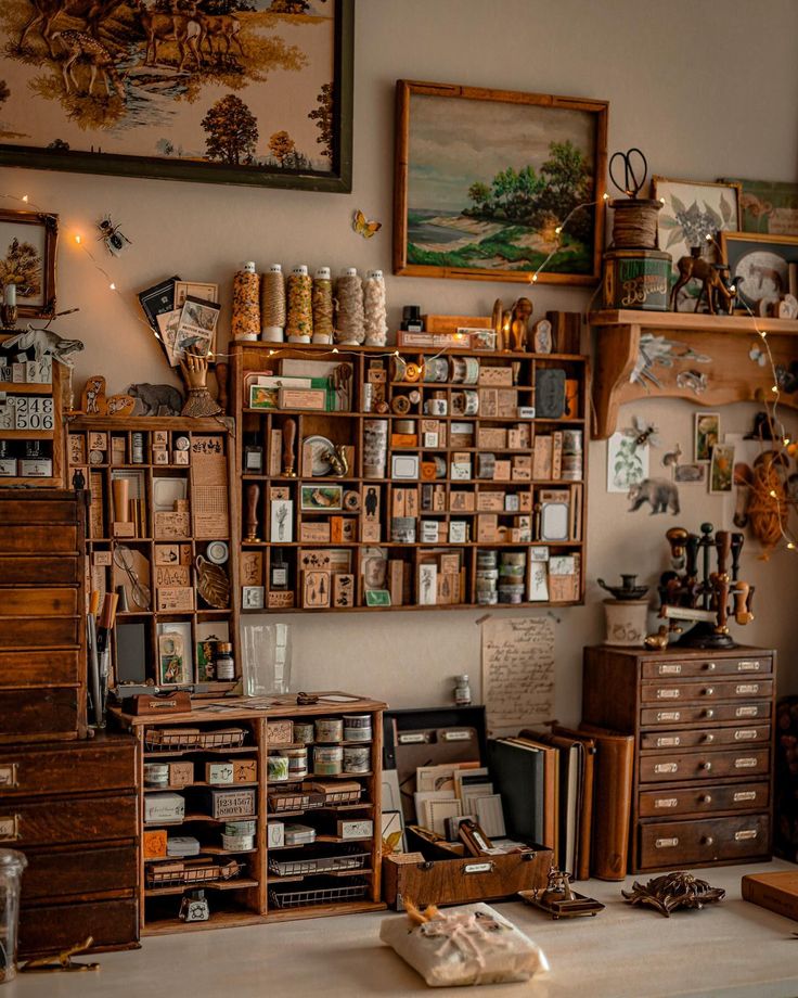 a room filled with lots of wooden boxes and drawers next to a painting on the wall