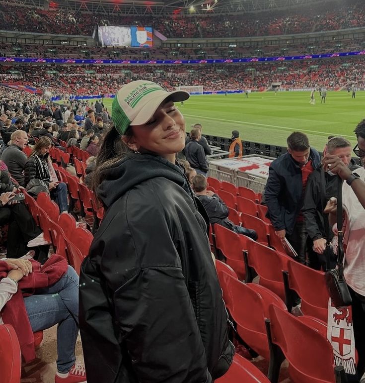 a woman standing in the stands at a soccer game