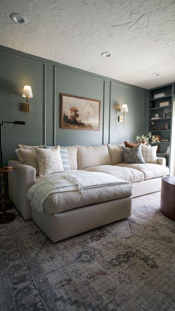 a living room filled with furniture next to a window covered in bookshelves and lamps