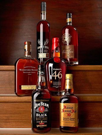 several bottles of liquor sitting on top of a wooden shelf