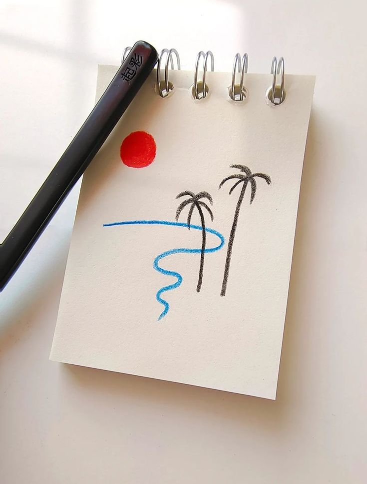 a notepad with a drawing of two palm trees and a red ball on it