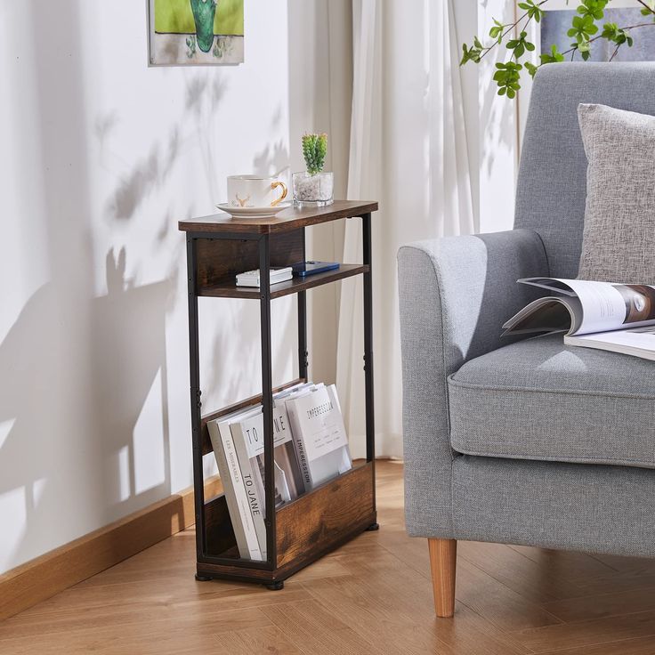 a living room with a chair, table and bookshelf on the floor in front of a window