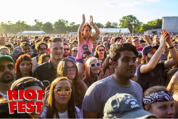 a large group of people standing in front of a crowd at a music festival with the words riot fest written on it