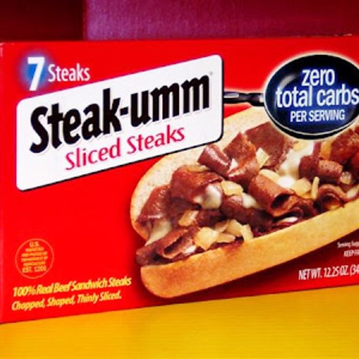 a box of steak - umm sliced steaks sits on a table in front of a red wall