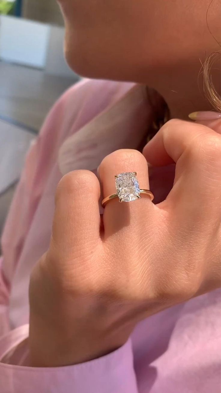 a close up of a person wearing a ring with a diamond on it's finger