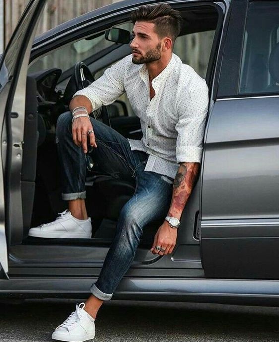 a man sitting in the back of a car with his foot on the door handle