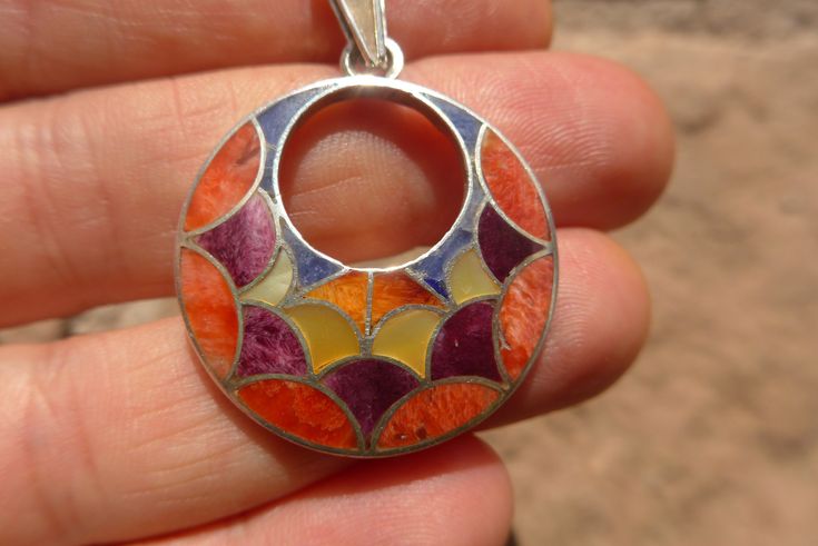 This is a beautiful Colorful Silver Pendant It is made by natural Gemstones and 950 Silver weight : 6 gr diameter: 2.8 cm height with hook : 4.1 cm It is handmade in 950 silver with inlaid stones by a local family of jewelry artisans. Nickel-free Multicolor Round Jewelry, Handmade Artisan Gemstones, Multicolor Round Sterling Silver Gemstones, Multicolor Inlay Jewelry For Gifts, Unique Handmade Round Gemstones, Bohemian Multicolor Round Gemstones, Multicolor Pendant Jewelry With Inlay, Multicolor Inlay Pendant Jewelry, Multicolor Pendant Inlay Jewelry