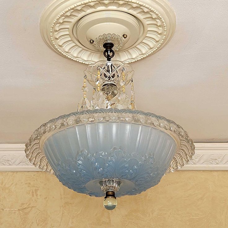 a chandelier hanging from the ceiling in a room with beige walls and white trim