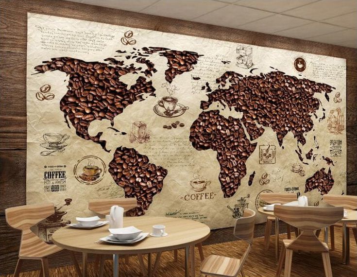 a large world map is on the wall in a restaurant with wooden tables and chairs