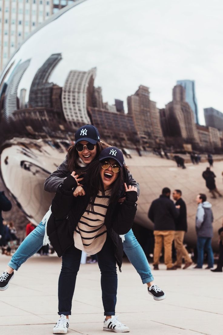 two people standing in front of a large mirror ball